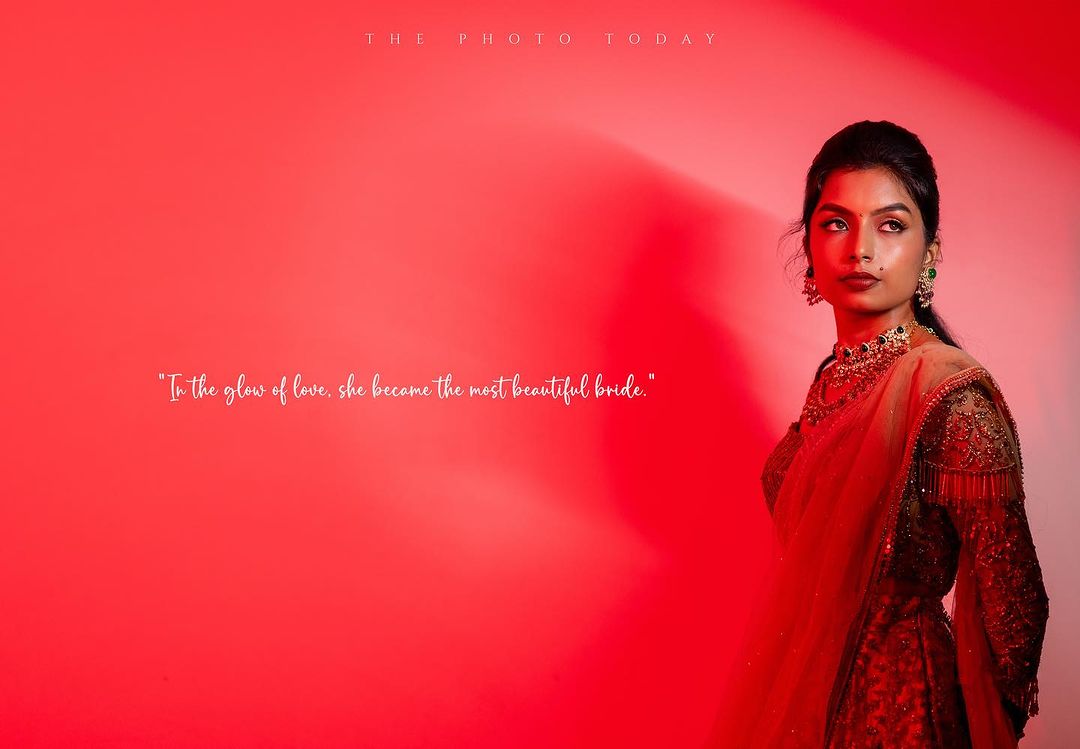 A stunning South Indian bride in a vibrant red lehenga, radiating elegance and grace.